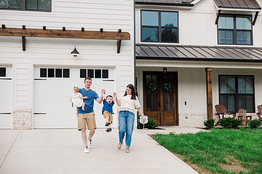 family of four in front of house
