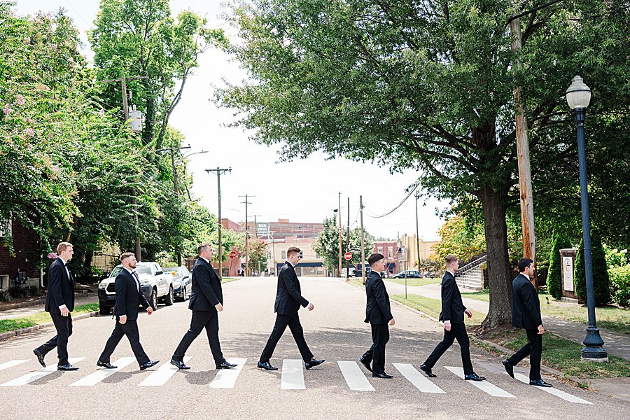 groom and groomsmen walk across street