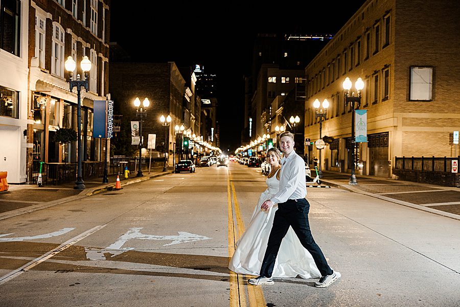 couple walking across street at night