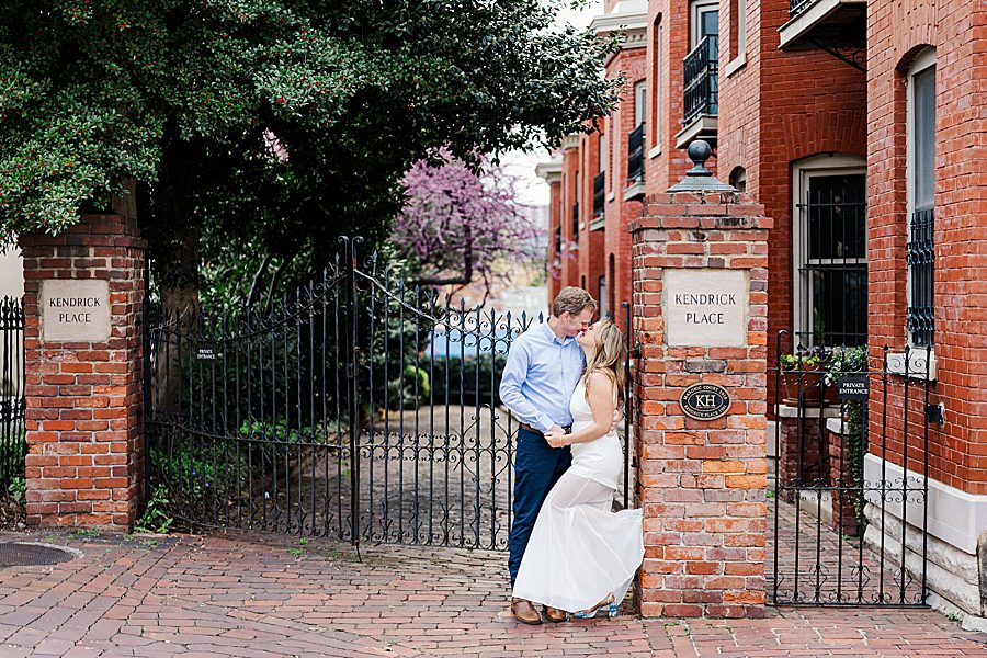couple leaning against brick mailbox at spring downtown knoxville engagement