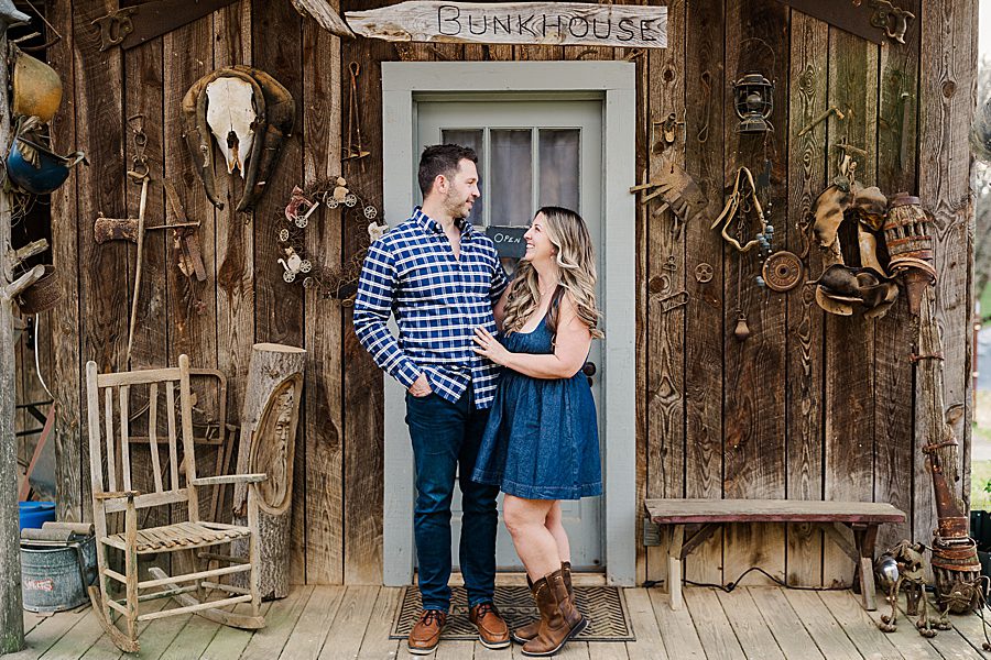couple on front porch at engagement session with a horse