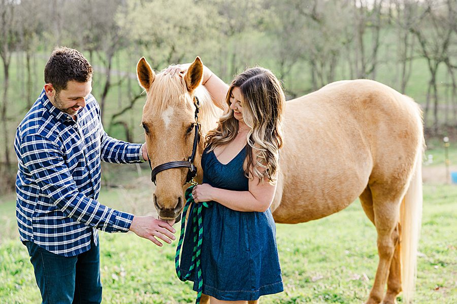 pet parents at engagement session with a horse