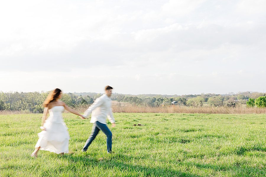 couple running through field at sunrise marblegate farm engagement