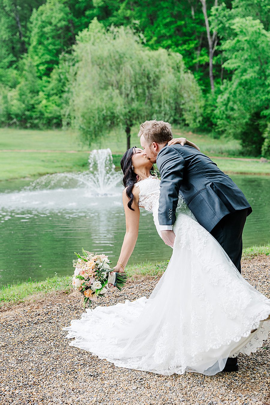 dip kiss by pond at rainy wedding at ramble creek