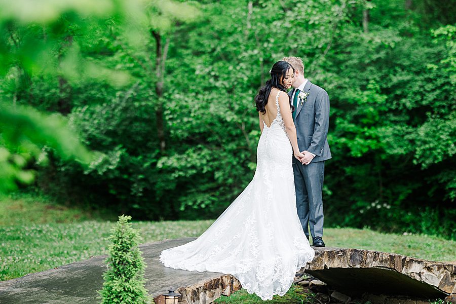 couple on bridge at rainy wedding at ramble creek