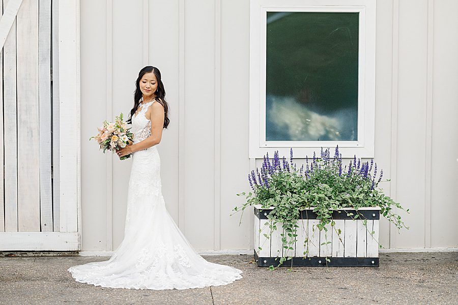 bride by lavender planter at rainy wedding at ramble creek