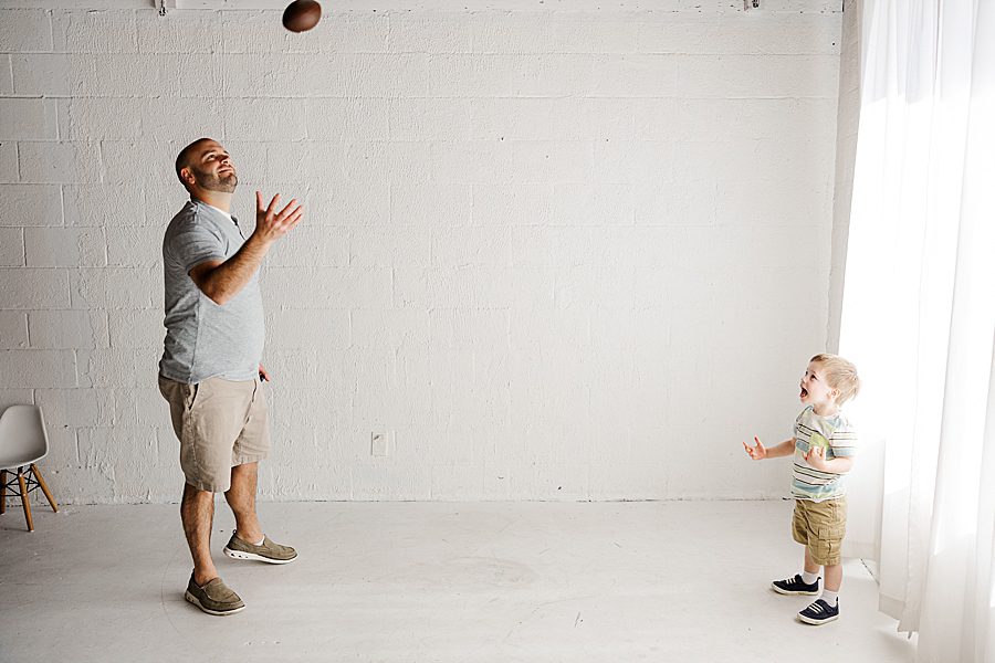 dad playing football with son during six week session