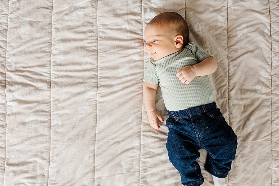 baby laying on neutral blanket