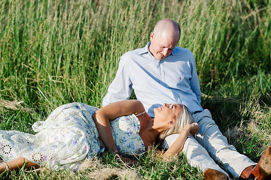 couple laying in meadow during marblegate engagement