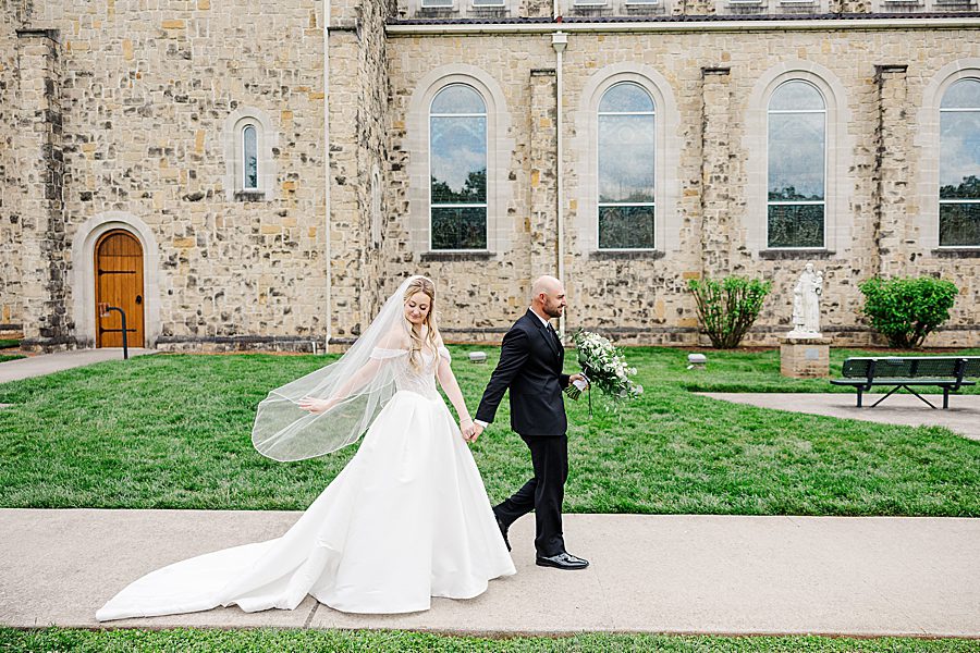 couple walking together at press room catholic wedding