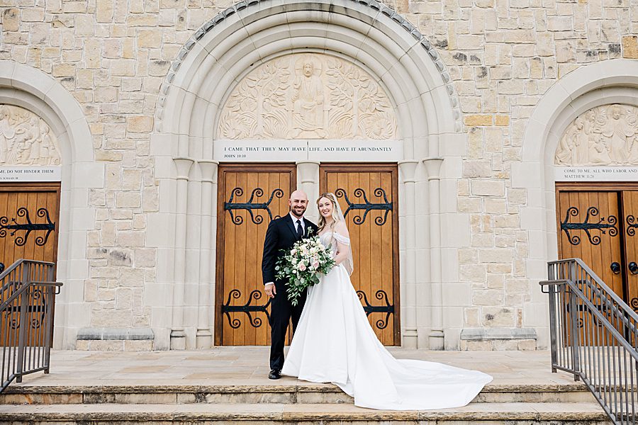 couple in front of church doors at press room catholic wedding
