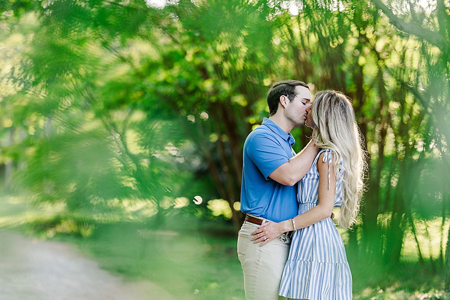 couple kissing at spring engagement at knoxville botanical