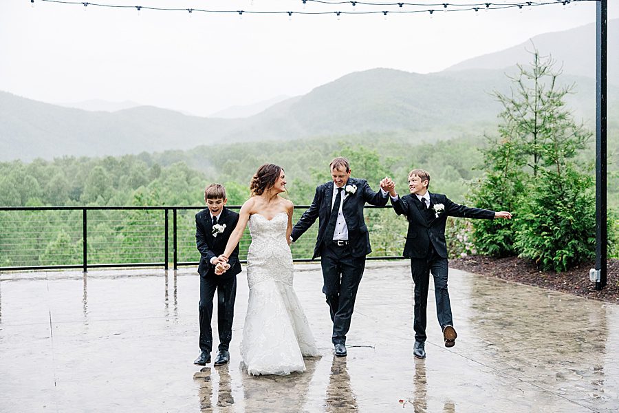 family playing in rain at trailhead venues wedding