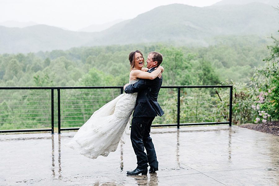 groom twirling bride in rain
