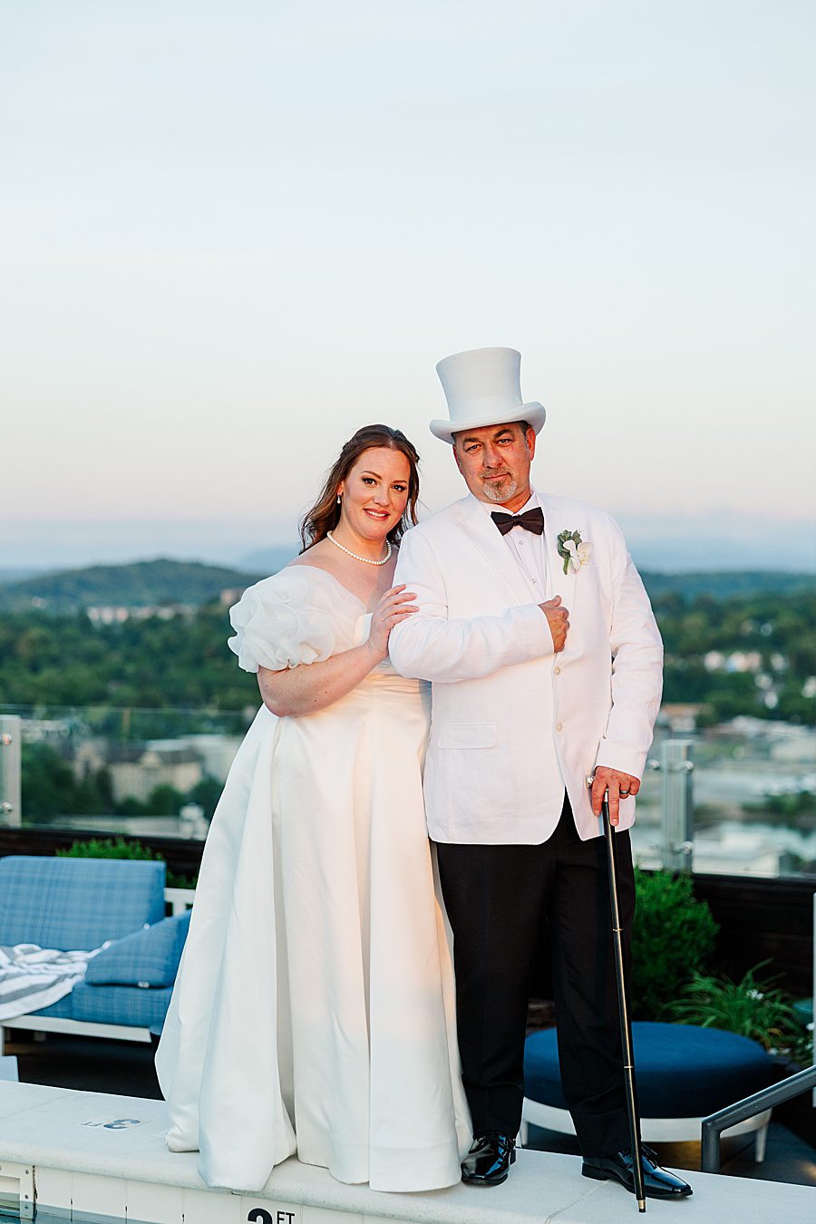bride and groom standing on roof top bar