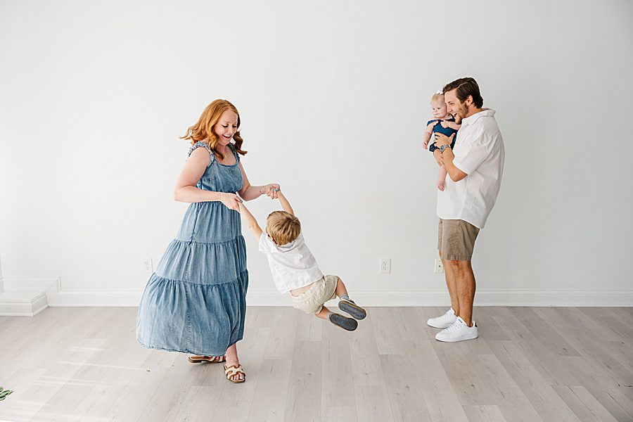 mom swinging son at white room one year session