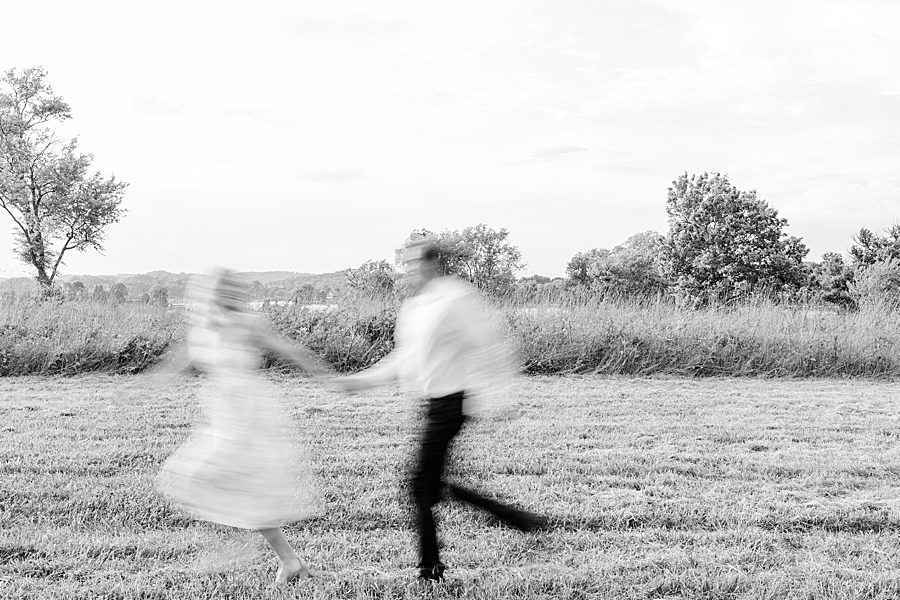 blurred black and white photo of couple running at rainy marblegate engagement