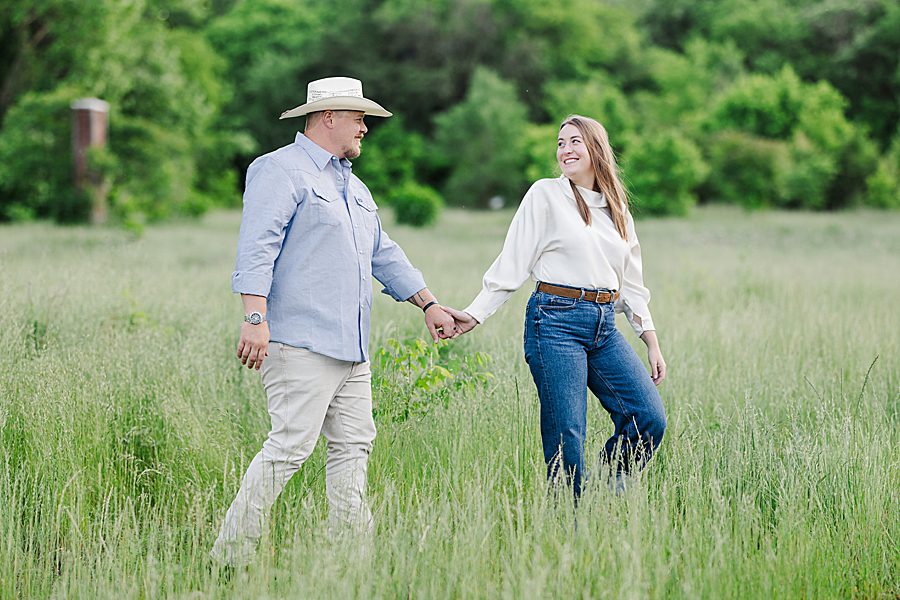couple holding hands in field at mead's quarry anniversary