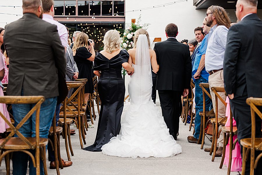 parents and bride walking down aisle to summer press room wedding