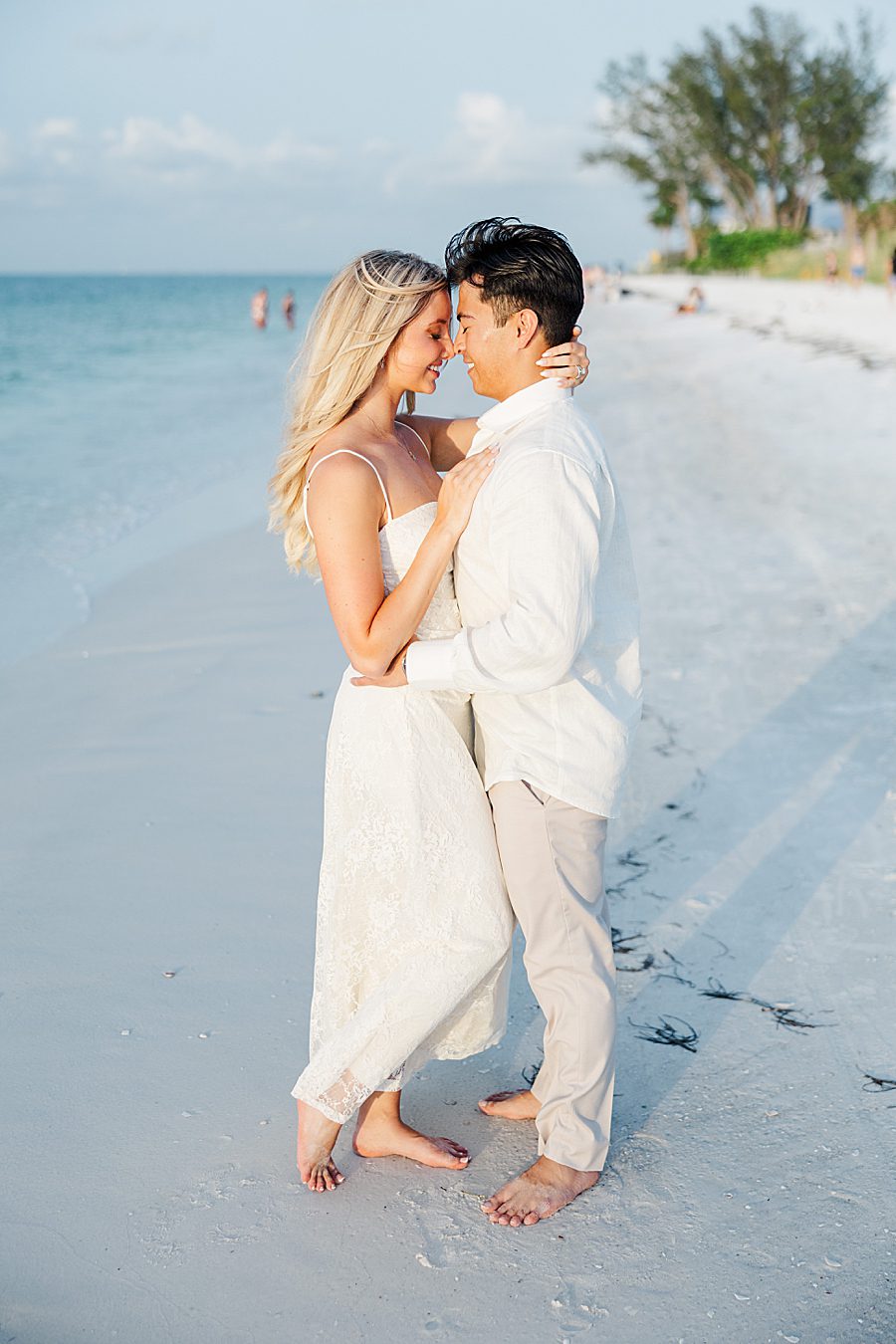 couple standing on beach at sunset at anna maria island anniversary session