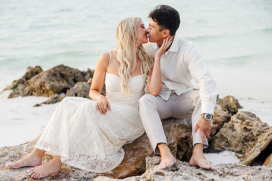 couple sitting on beach rocks during photography session