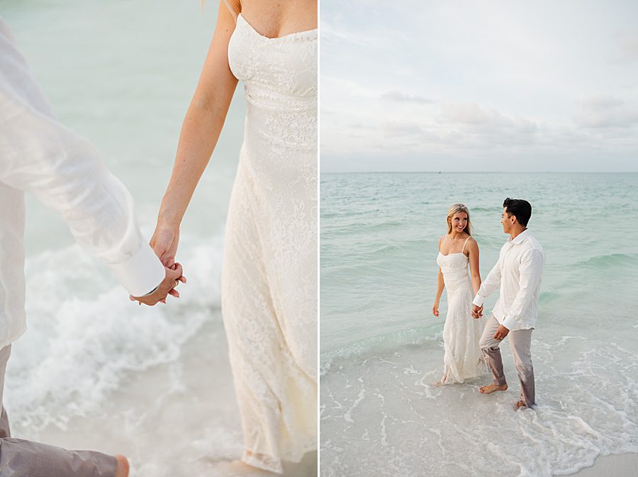 couple holding hands while walking on beach