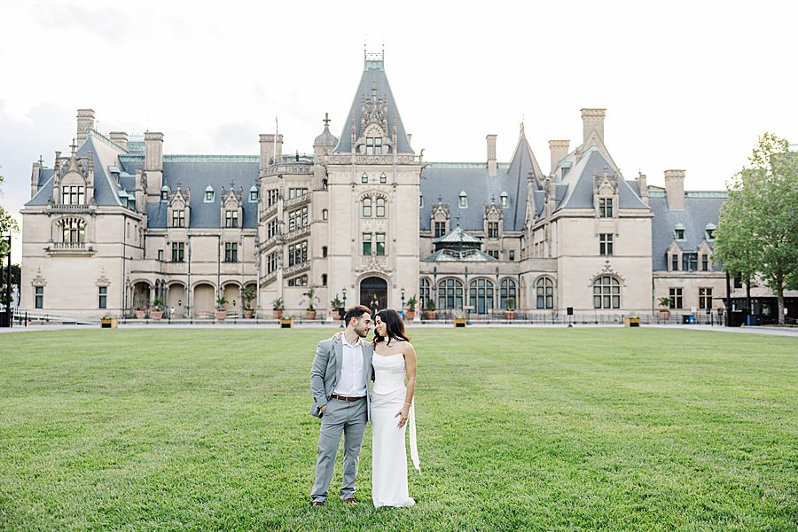 couple in front of large manor