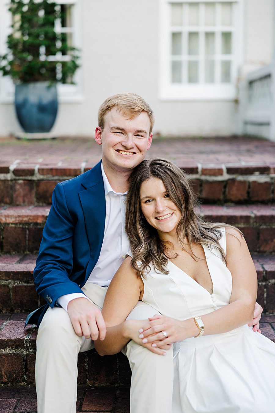 couple sitting on brick steps at maple grove engagement session