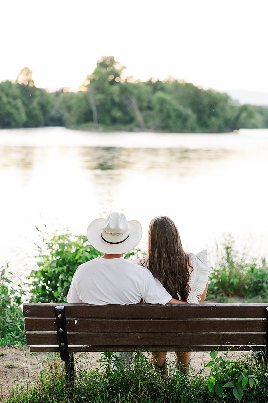 couple sitting on bench overlooking water