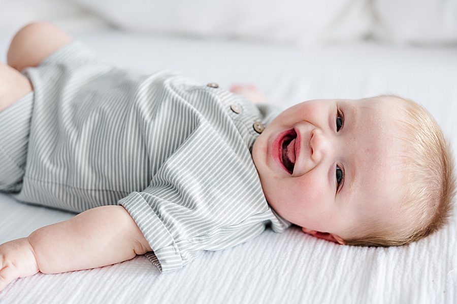 baby laying down during white room family session