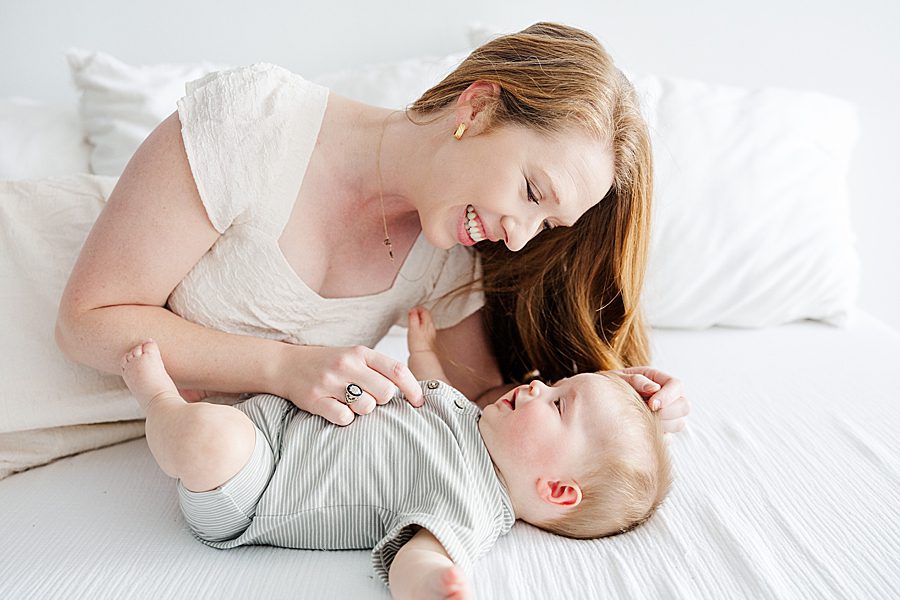 mom playing with son at white room family session