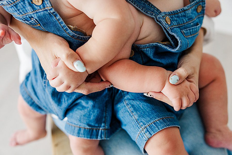 mom and babies holding hands at nine month twins milestone session