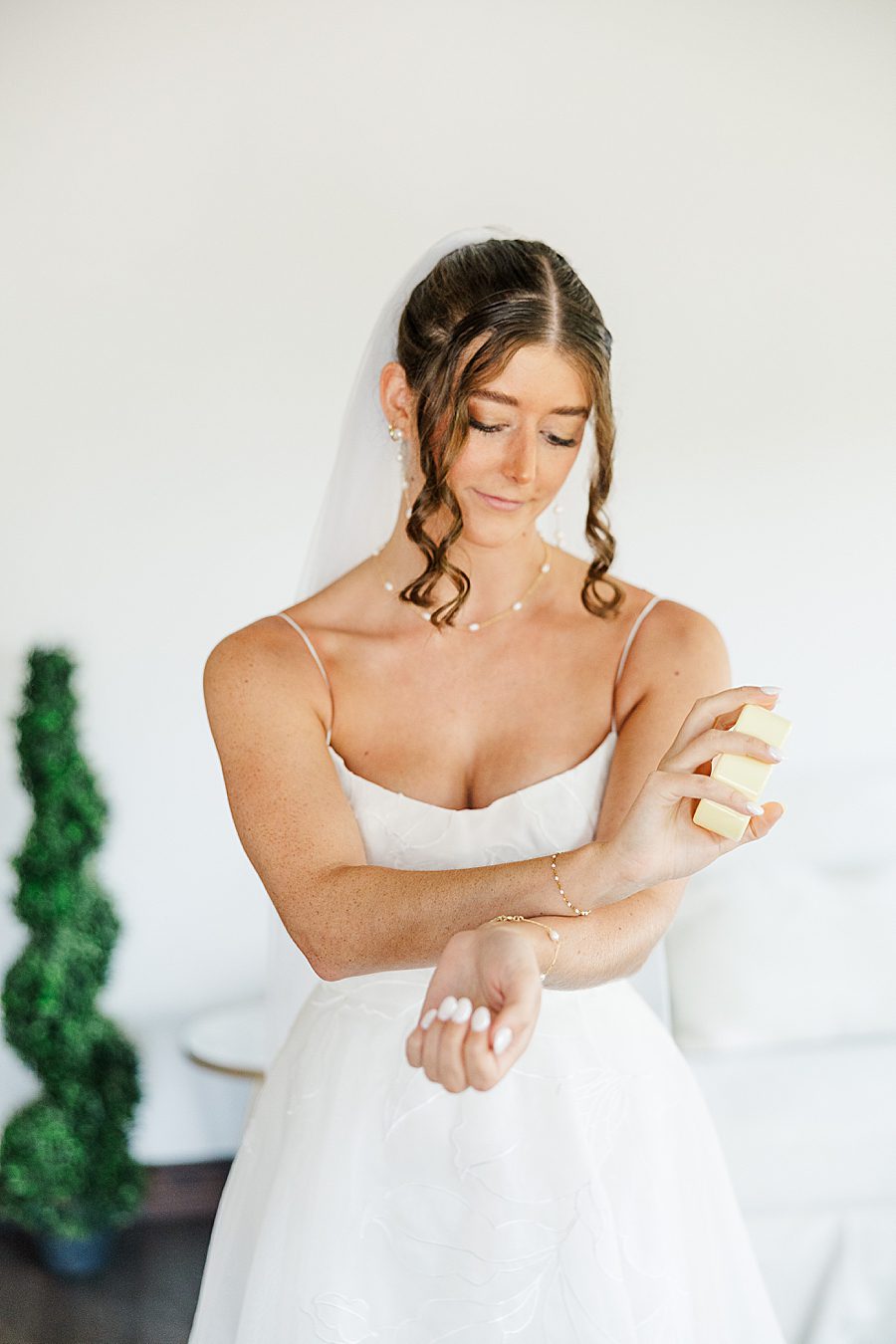 bride putting on perfume for wildflower event center wedding