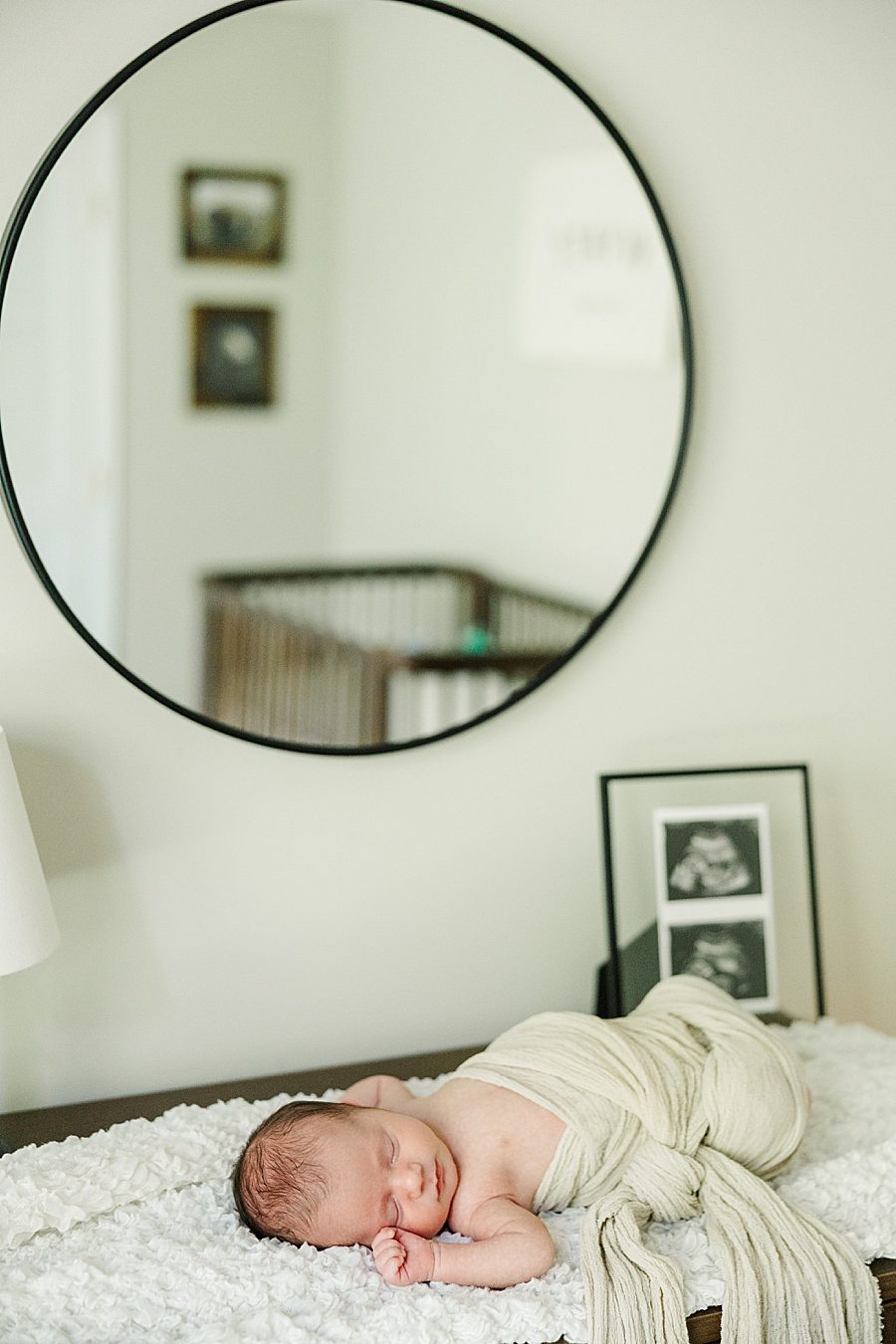 swaddled baby laying on dresser