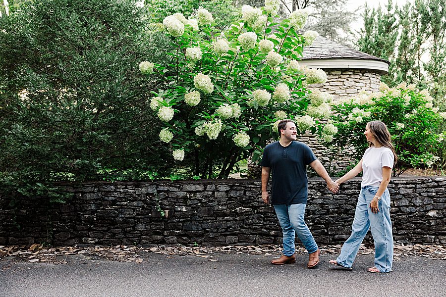 couple walking in front of hydrangea at associate knoxville botanical engagement