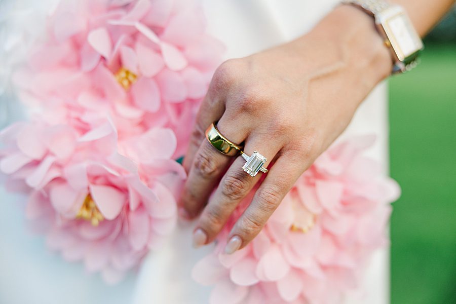 woman holding pink blooms with rings on hand