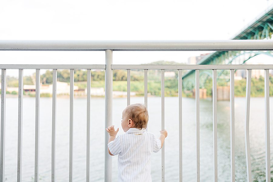 boy standing in front of tennessee river at baby's first year session