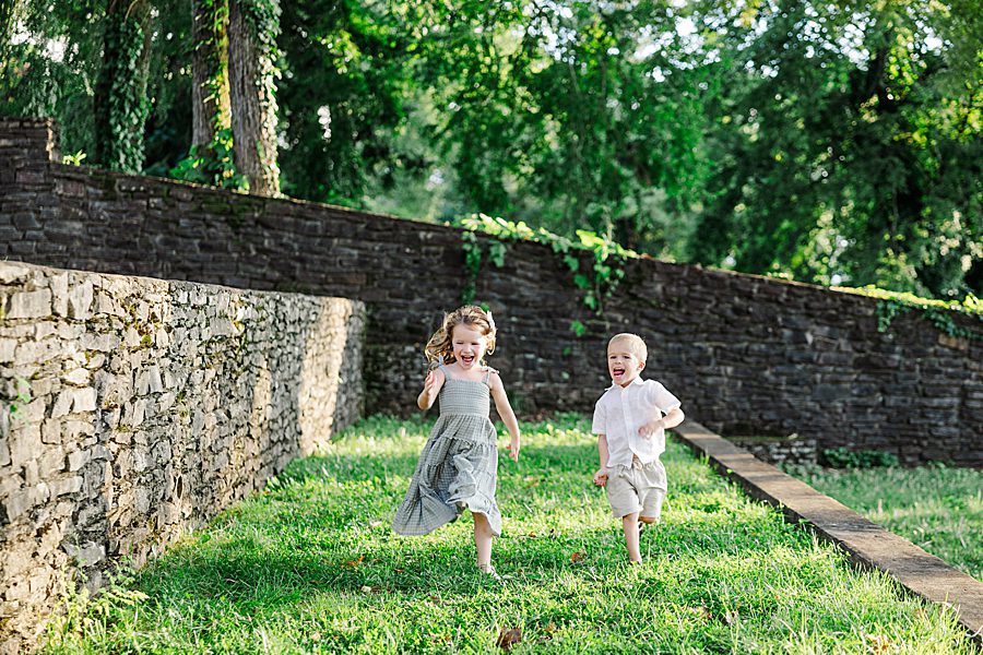 siblings running through grass together