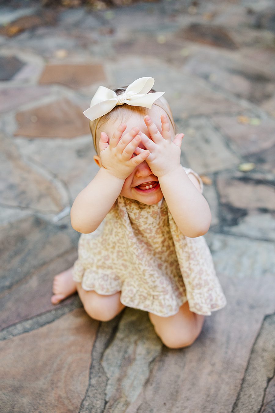 baby girl playing peek a boo