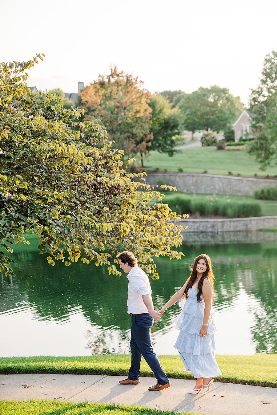couple walking by manmade water feature at farragut engagement session
