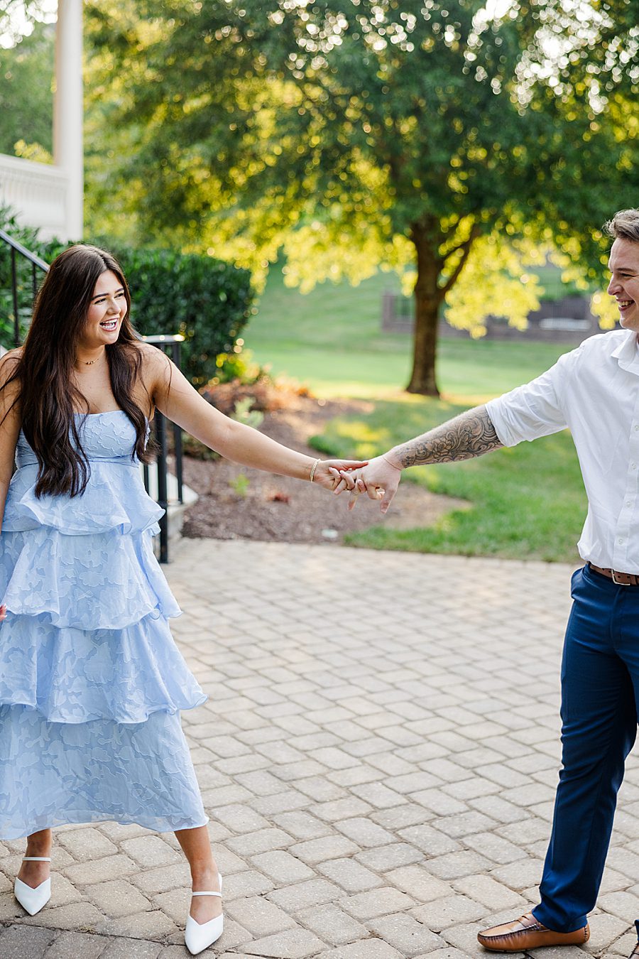 couple holding hands and walking on path