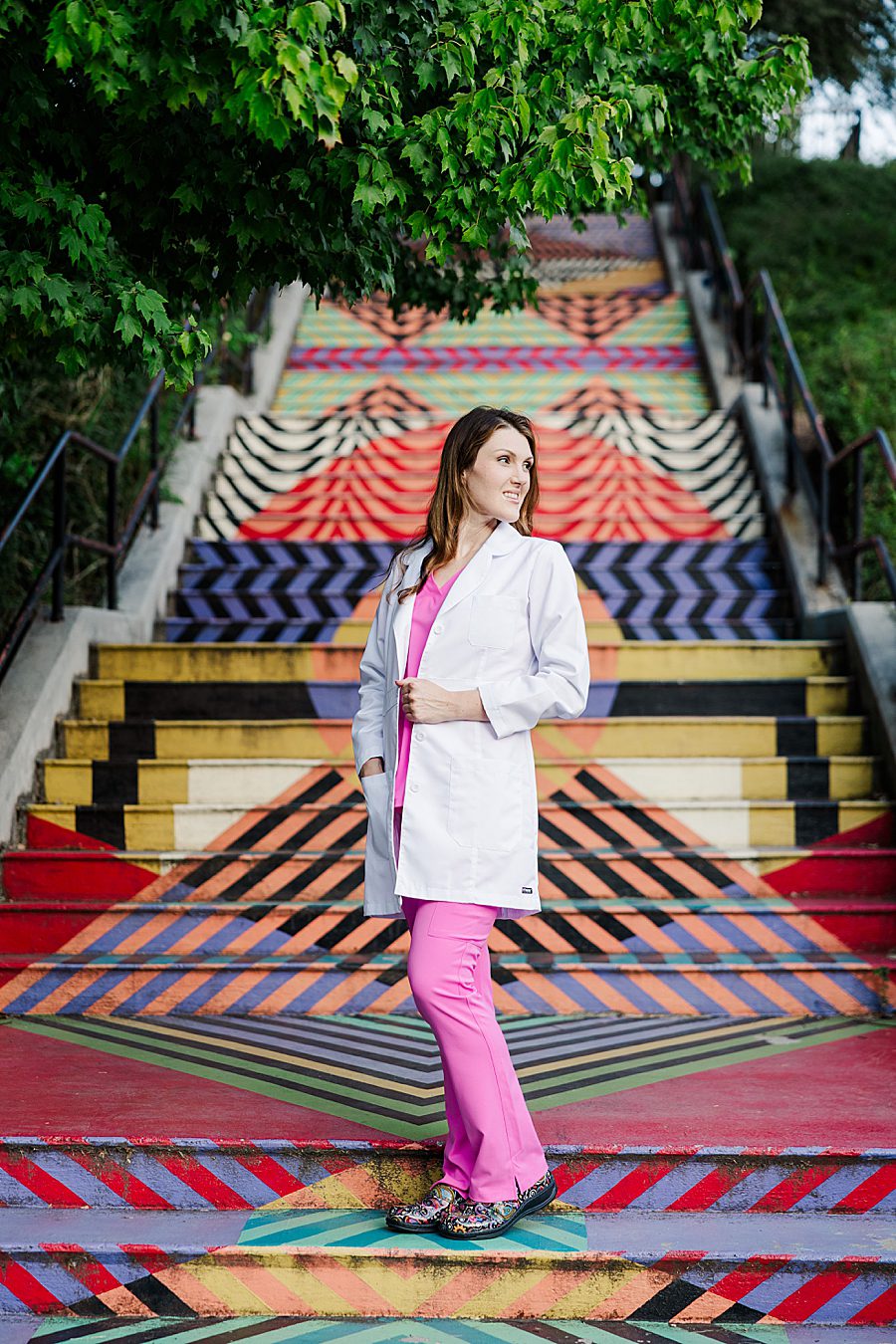 woman wearing hot pink scrubs and white lab coat