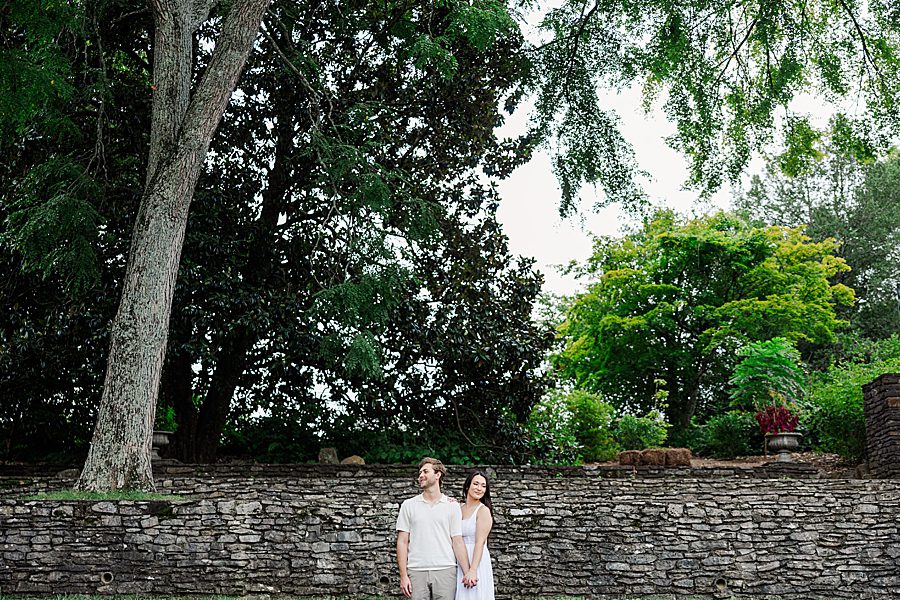 couple in front of stone wall at knoxville botanical summer engagement