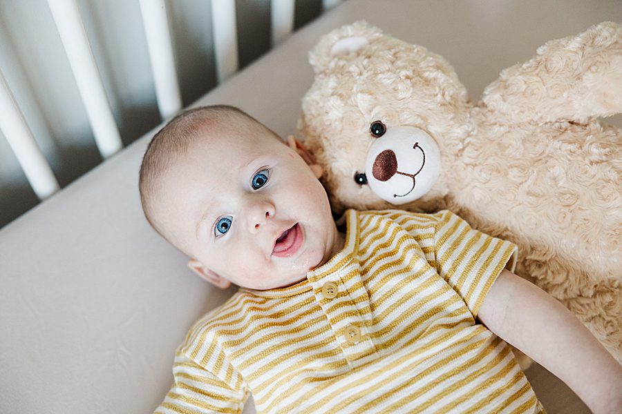 baby boy with teddy bear in crib at powell home milestone session