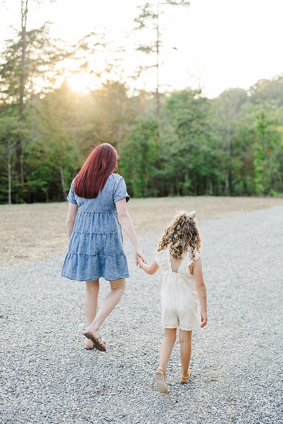 mom and daughter walking together at golden hour