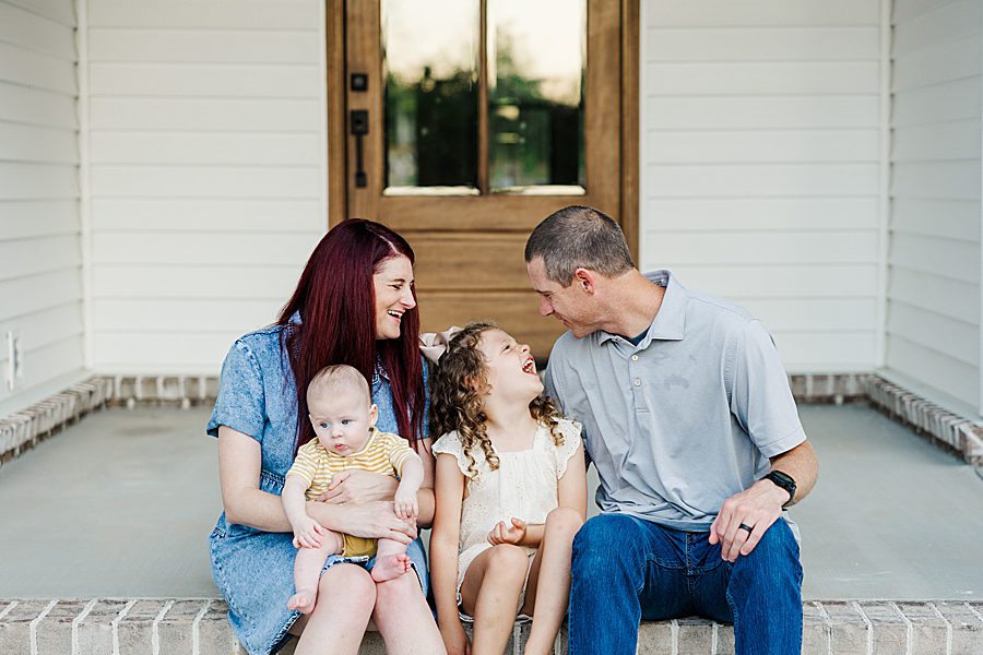 family of 4 sitting on front porch