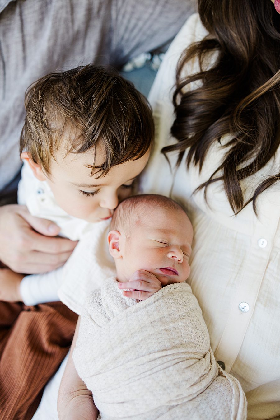 big brother kissing baby brother's head