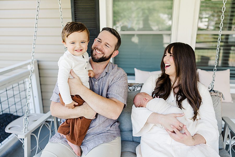 family of four sitting on porch swing