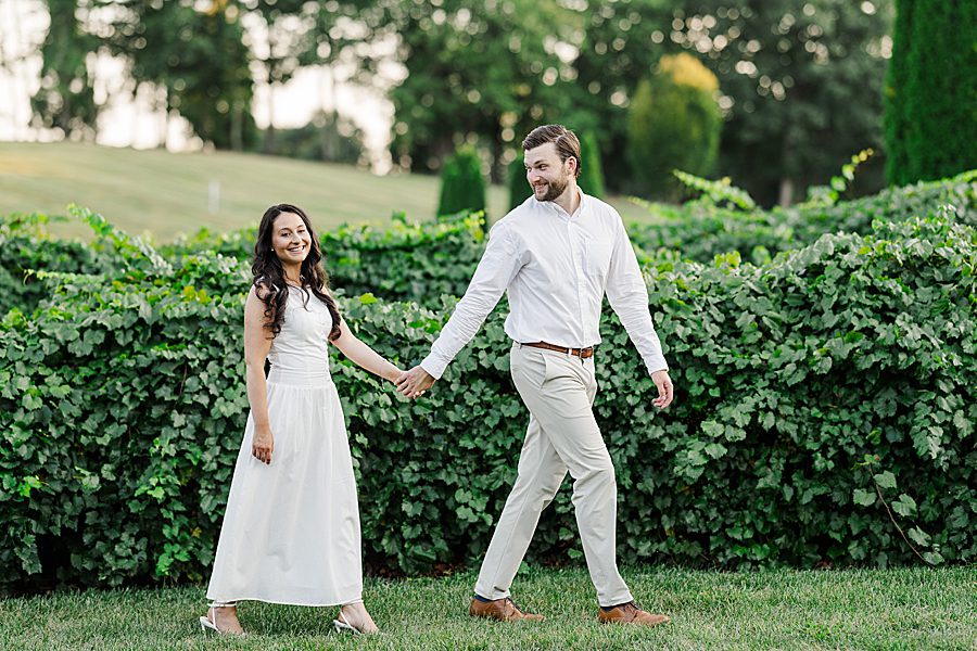 couple walking by vineyard at castleton estate engagement session
