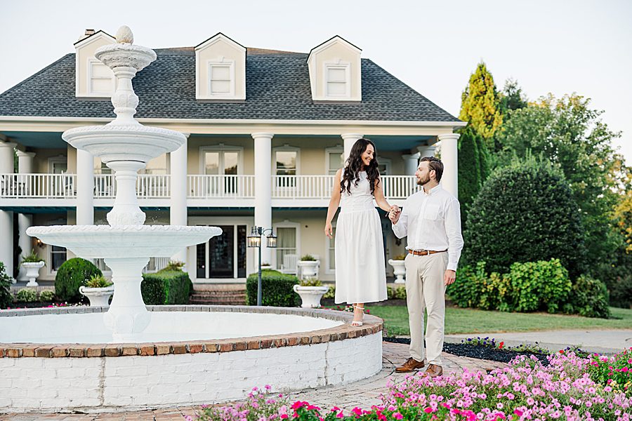 couple walking next to white fountain
